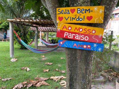 a sign on a tree in a park at Casa de Japaratinga in Japaratinga