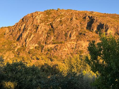 a large mountain with trees in front of it at Cortijo Los Cahorros Sierra Nevada in Monachil