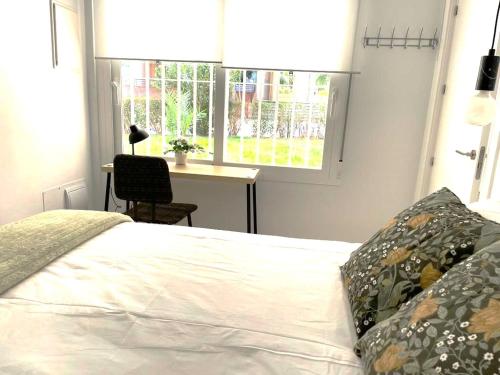 a bedroom with a bed with a desk and a window at office 25 in Tres Cantos