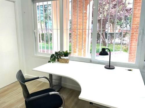 a white desk with a chair and a window at office 25 in Tres Cantos