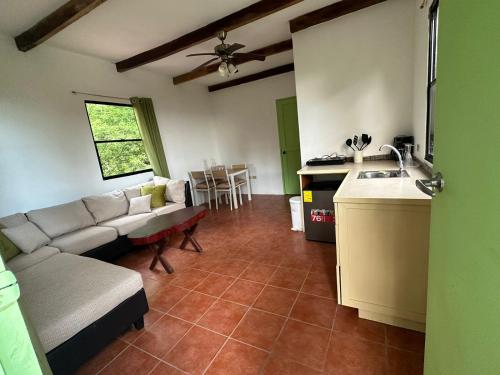 Hotel Zelen في Tamanique: غرفة معيشة مع أريكة ومطبخ