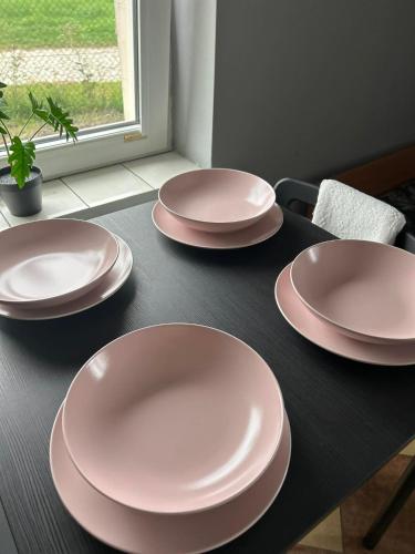 four pink plates sitting on a black table at Lawendowa Przystań - Dolina Baryczy in Ujeździec Mały