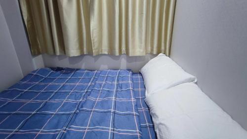 a small bedroom with a bed and a curtain at M18 Station 103,107 in Hong Kong