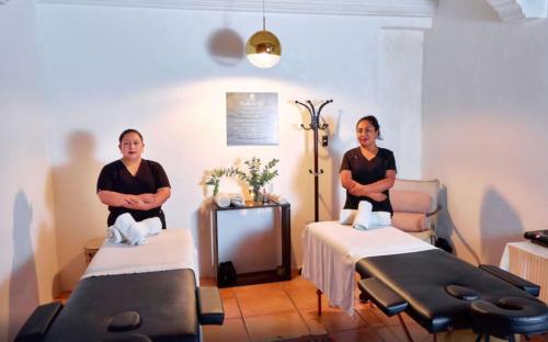 dos hombres sentados en una habitación con sillones de masaje en Naif Boutique Hotel, en Antigua Guatemala