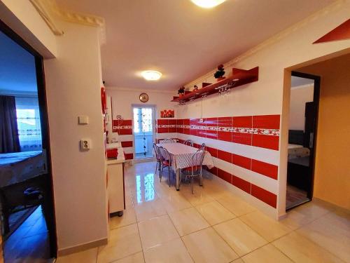 een eetkamer met rode en witte strepen aan de muur bij Apartman Lux in Covasna