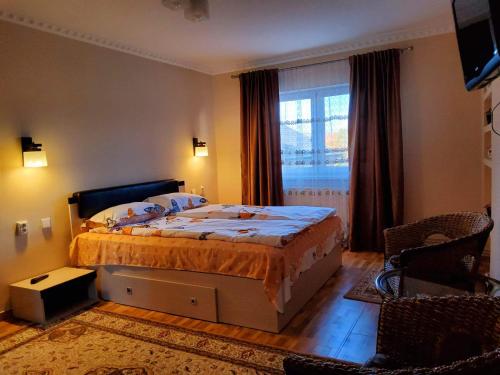 a bedroom with a large bed and a window at Apartman Lux in Covasna