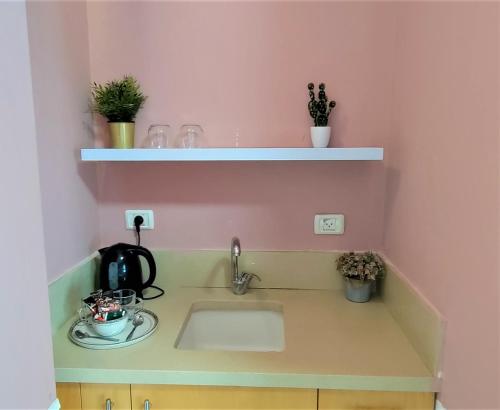 a kitchen with a sink and a pink wall at Jako Boutique in Jerusalem