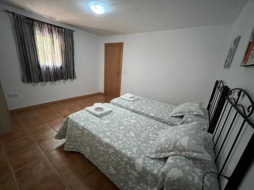 a bedroom with a bed with two towels on it at Cortijo Los Cahorros Sierra Nevada in Monachil