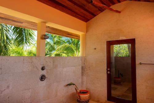 baño con ventana y ducha a ras de suelo en Mission Bay, en Maya Beach