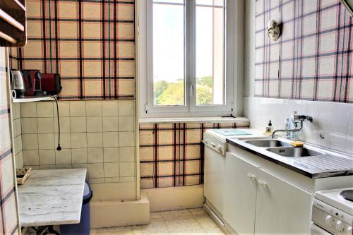 une cuisine avec un évier et une fenêtre dans l'établissement L'Aigue Marine, à Royan