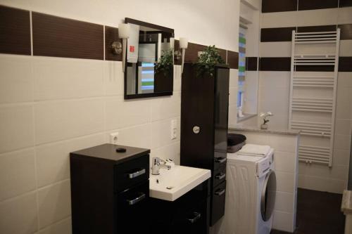 a small bathroom with a sink and a mirror at Bello Apartamento in Graben-Neudorf