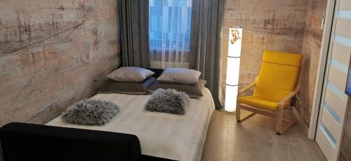 a bedroom with two beds and a yellow chair at COMFORT Apartment Pawia street - free parking !!! in Krakow