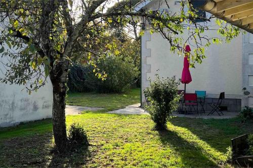 a yard with a tree and a table and chairs at Villa coutrillonne près St Emilion [clim salon] in Coutras
