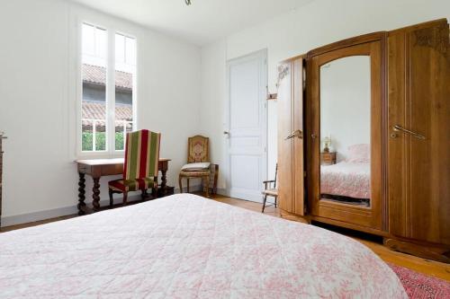 a bedroom with a large bed and a dresser at Villa coutrillonne près St Emilion [clim salon] in Coutras