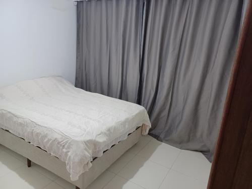 ein kleines Bett in einem Zimmer mit Fenster in der Unterkunft Aluga-se quarto em apartamento in Ipatinga