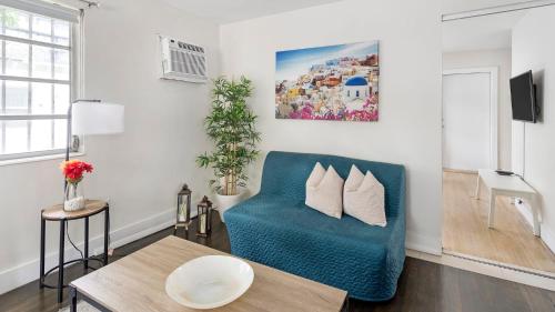 a living room with a blue couch and a table at Brickell Pearl Cozy House Beach 10 min Location in Miami