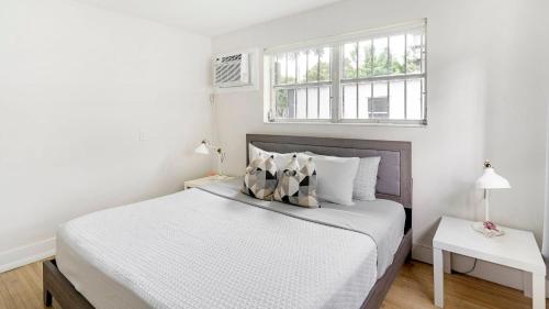 a white bedroom with a bed and a window at Brickell Pearl Cozy House Beach 10 min Location in Miami
