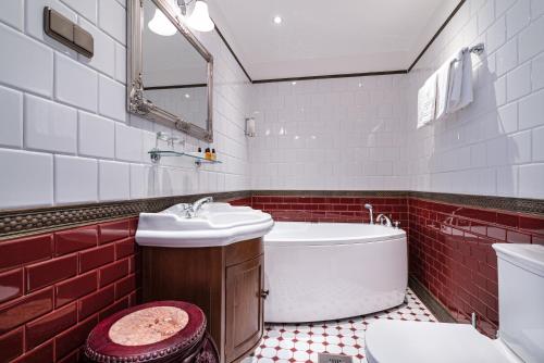 a bathroom with a tub and a sink and a toilet at Padise Manor in Padise