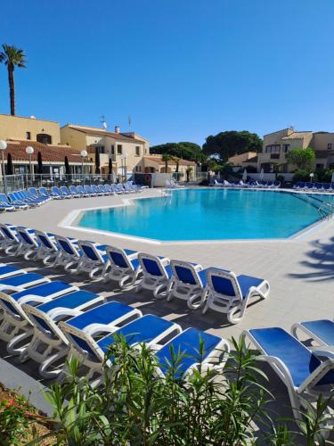 - un groupe de chaises longues devant la piscine dans l'établissement STUDIO CLIMATISE box 5 G Résidence Odalys Saint Loup, piscine ,parking privé et superette 25, au Cap d'Agde