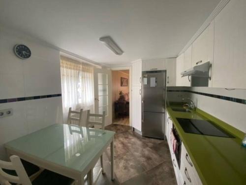 a kitchen with a table and a green counter top at Apartado y cerca de todo in Cotorrio