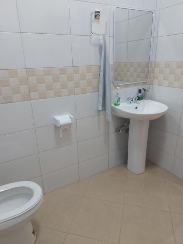 a bathroom with a toilet and a sink at Freeve Suites Akright City Bwebajja in Buzzi