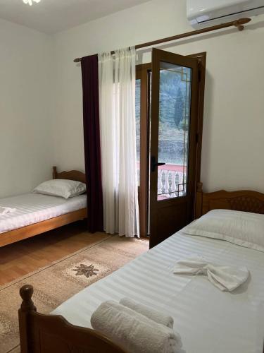 a bedroom with two beds and a window at Guesthouse Space in Përmet