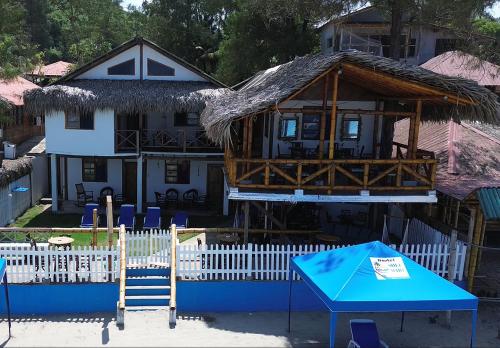 a building with a house with a thatch roof at Hotel SoleMare in Montañita