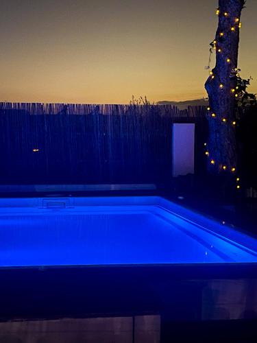 a blue swimming pool in front of a fence at Asteria Apartments in Analipsi