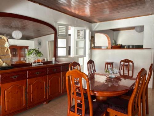 a kitchen with a wooden table and a dining room at Villa à louer à Sainte-Anne en Martinique in Sainte-Anne