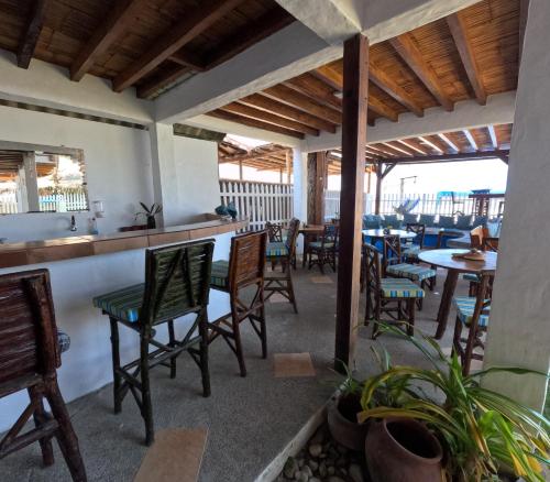 un restaurante con sillas y mesas y un bar en Hostal SoleMare en Montañita