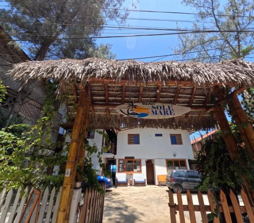 a restaurant with a thatch roof over a gate at Hotel SoleMare in Montañita