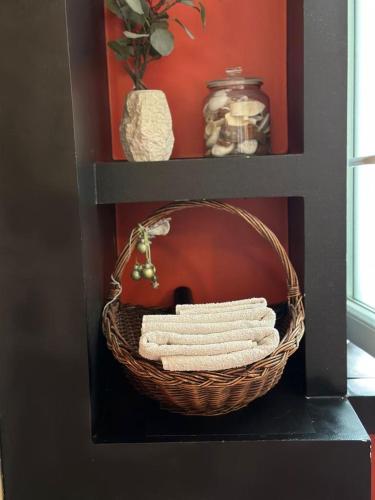 a basket of towels sitting on a shelf with a shelf at Jacuzzi Apartment - Center Zagreb in Zagreb