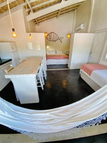 a hammock in a room with two beds and a bedroom at Nordestina Loft in Icaraí