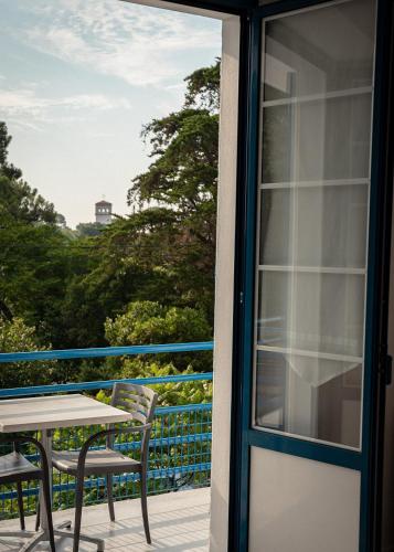 a patio door with a table and chairs on a balcony at Hotel Mercedes in Hossegor
