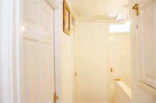 Una puerta blanca en una habitación blanca con ventana en Spacious 4 Bed Home in Milton Keynes -free parking en Milton Keynes
