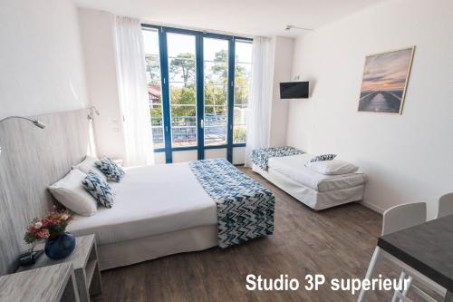 a hotel room with a bed and a window at Hotel Mercedes in Hossegor