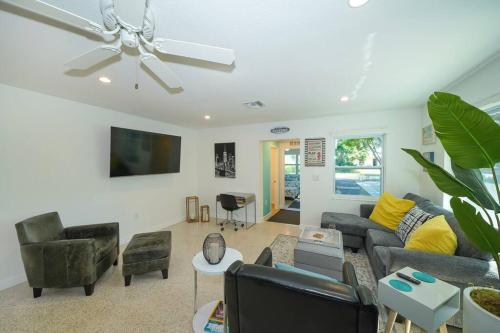 a living room with a couch and chairs and a ceiling fan at Modern, Fresh - Only 3 miles to the Beach! in Sarasota
