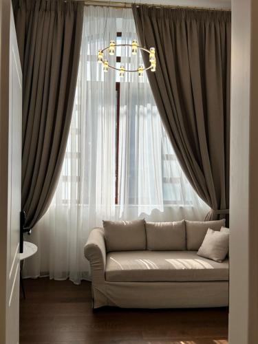 a living room with a couch in front of a window at Jensen Luxury Suites in Rhodes Town