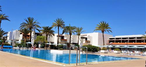 una gran piscina con palmeras y edificios en Ke Casetta Tenerife, en Costa del Silencio
