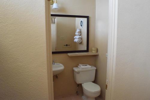 a bathroom with a toilet and a sink and a mirror at Imperial Motel in Odessa