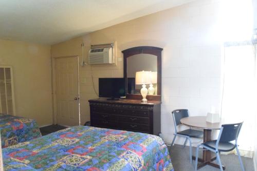 a bedroom with a bed and a table with chairs at Imperial Motel in Odessa