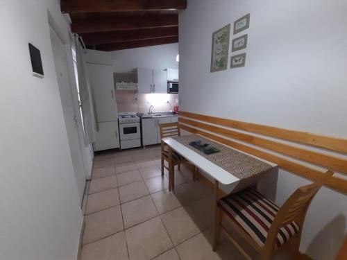 a kitchen with a table and chairs in a room at Monseñor Fagnano 592 "D" in Ushuaia
