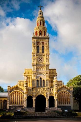 a large building with a tower with a clock on it at Bienvenue a la marine Saint benoit 2 in Saint-Benoît
