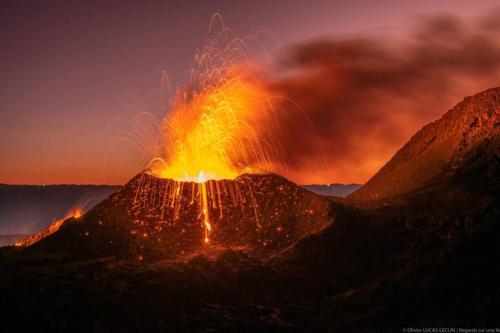 an erupting volcano at night with smoke and flames at Bienvenue a la marine Saint benoit 2 in Saint-Benoît