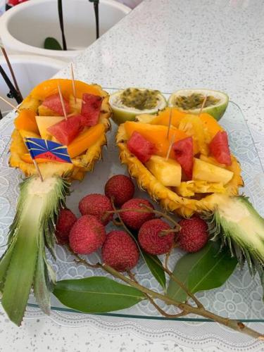 a plate with fruit and berries on a table at Bienvenue a la marine Saint benoit 2 in Saint-Benoît