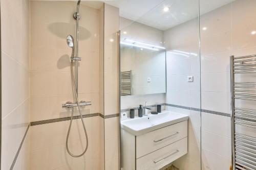 y baño blanco con lavabo y ducha. en Splendid 1BR Apt in Lazare Hoche, en Boulogne-Billancourt