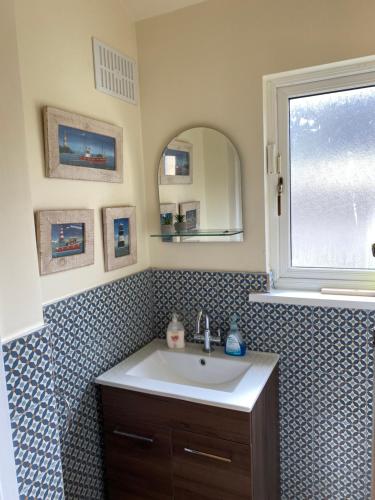 ein Bad mit einem Waschbecken und einem Spiegel in der Unterkunft Church View House in Kells