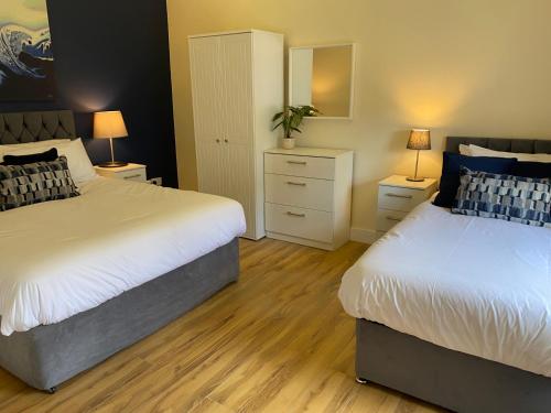 a bedroom with two beds and a dresser with two lamps at Church View House in Kells