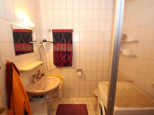 een badkamer met een wastafel, een toilet en een douche bij Holiday home Renate, Nessmersiel in Neßmersiel