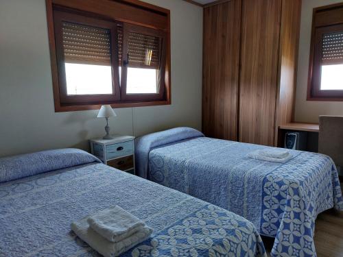 sypialnia z 2 łóżkami i 2 oknami w obiekcie Apartamentos El Prau w mieście Ubiarco